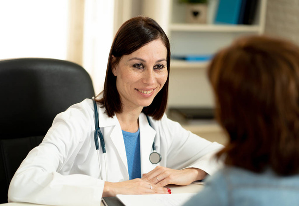 Smiling female doctor and happy patient talking and consulting in hospital clinic office in Health care, professional medical staff, happy hospital environment, Insurance and Medical trust concept. - Photo, Image