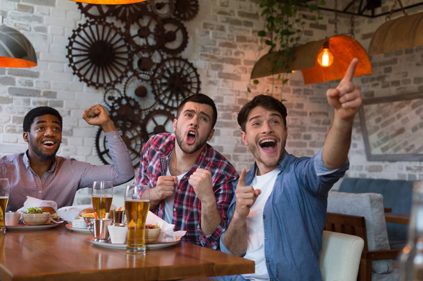 Freunde schauen Fußballspiel im Fernsehen und trinken Bier - Foto, Bild