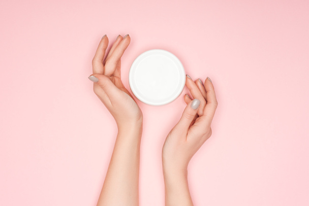 top view of female hands with body cream isolated on pink - Photo, image