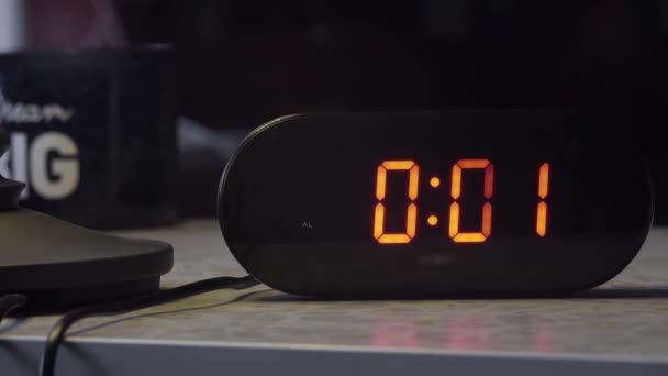 Reloj digital electrónico en forma rectangular negro indica la hora en color naranja
 - Metraje, vídeo