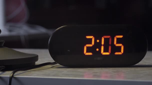 Černá obdélníková tvarované plastové digitální hodiny ukazuje čas v oranžové barvě - Záběry, video