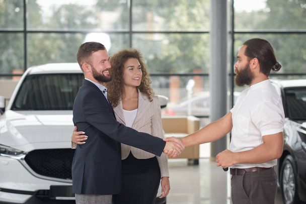 Men shaking hands, couple purchasing automobile. - Fotoğraf, Görsel