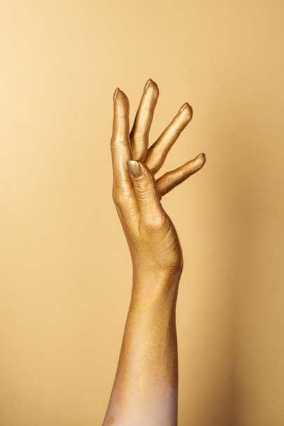 cropped view of female painted hand on golden background - Фото, изображение