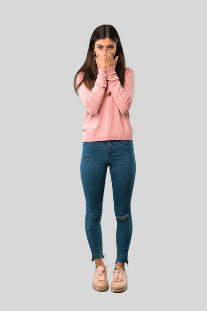Full body of Teenager girl with pink shirt smiling a lot while covering mouth on isolated grey background - Foto, Bild