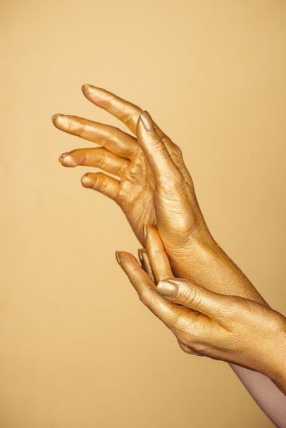 partial view of female painted hands isolated on gold - Fotó, kép