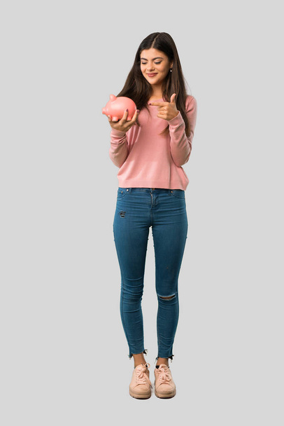 Koko kehon teini tyttö vaaleanpunainen paita tilalla poreallas eristetty harmaa tausta
 - Valokuva, kuva