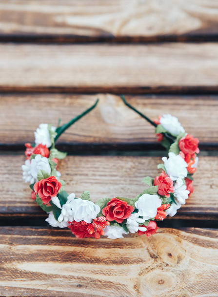 Handmade hoop red and white flowers. Red and white hair band on wooden background - Photo, Image