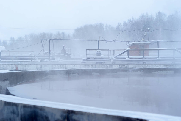 jäteveden käsittelylaitos talvella, jäiset primaariasfalttisäiliöt
 - Valokuva, kuva