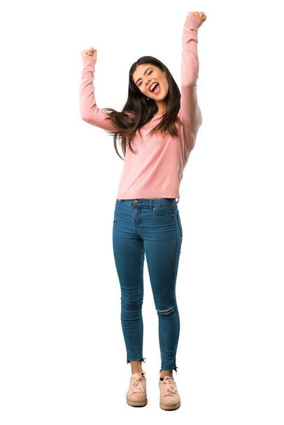 A full-length shot of a Teenager girl with pink shirt celebrating a victory in winner position - Photo, Image