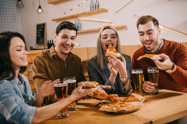 glückliche Frau isst Pizza bei Freunden in Bar - Foto, Bild