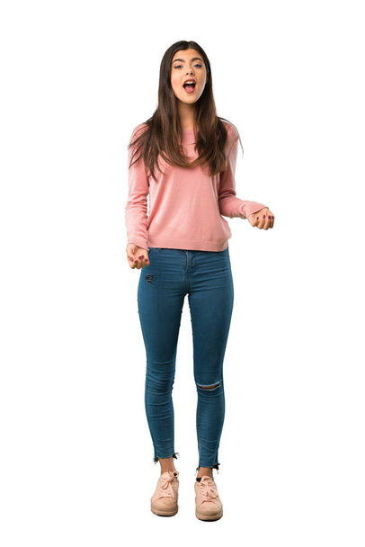 Sürpriz ve şok yüz ifadesi ile pembe gömlek bir genç kızla tam uzunlukta bir kadeh - Fotoğraf, Görsel