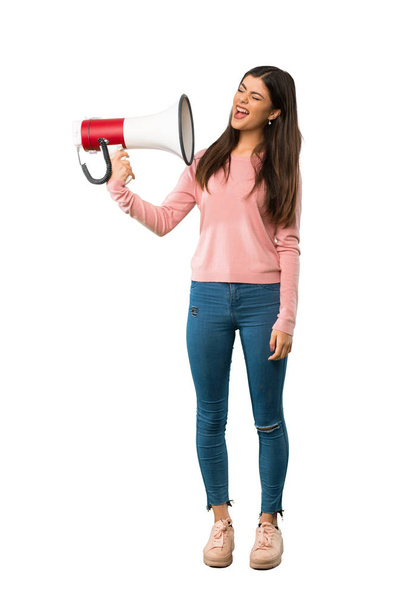 A full-length shot of a Teenager girl with pink shirt taking a megaphone that makes a lot of noise - Fotó, kép