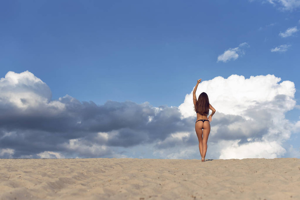Caminhe com uma morena na areia quente
 - Foto, Imagem