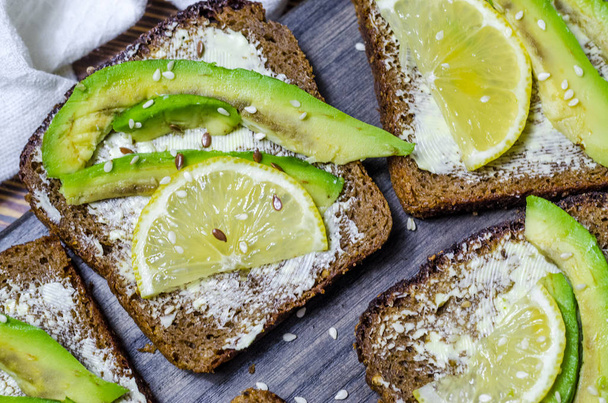 black bread diet sandwich with avocado and lemon close up - Фото, зображення