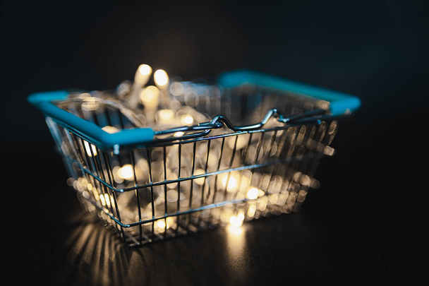 shining shopping cart with fairy lights bokeh inside shot at shallow depth of field, metaphor of selling and promoting your best products - Photo, Image