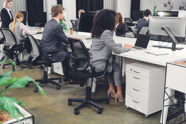 jeunes gens d'affaires professionnels en tenue formelle travaillant avec des appareils numériques dans un bureau à aire ouverte
 - Photo, image