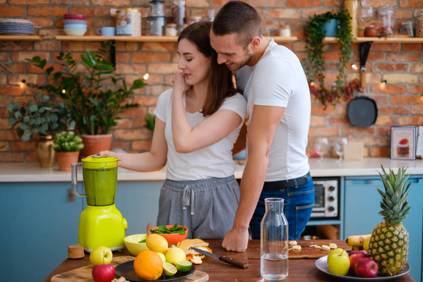 Νεαρό ζευγάρι κάνει smoothie στην κουζίνα - Φωτογραφία, εικόνα