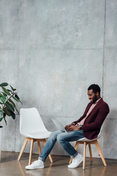 afro-amerikai alkalmi üzletember ül, és használ a laptop az utasforgalmi épület - Fotó, kép
