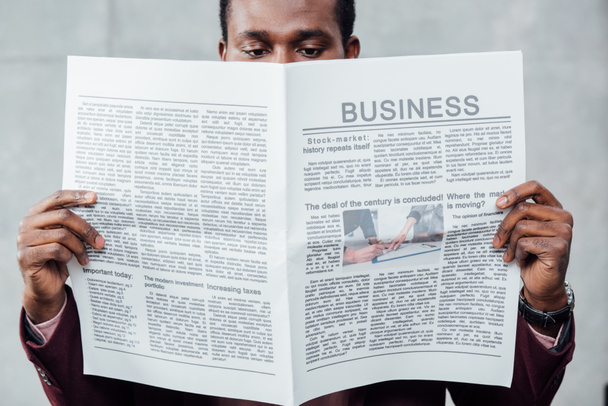 επικεντρώθηκε Αφρικανικός Αμερικανός επιχειρηματίας casual διαβάζοντας εφημερίδα - Φωτογραφία, εικόνα