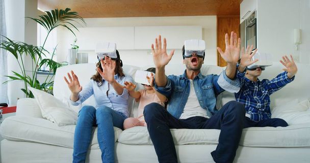 Portrait of happy family using vr glasses in living room in slow motion. Concept of innovation technology, family entertainment, game - Photo, image