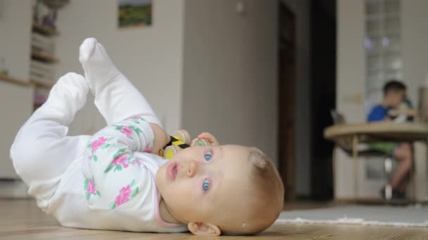Une petite fille en costume de barboteuse couchée sur le sol
 - Séquence, vidéo
