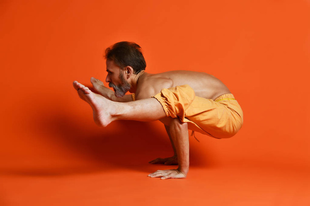 Sporty senior man doing Arm balance exercise for strength, yoga, pilates training, - Photo, Image