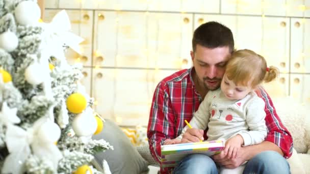 father teaches little daughter to draw at Christmas time - Záběry, video