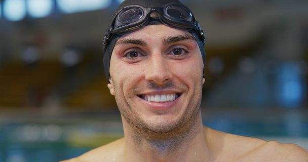 Retrato de nadador profesional sonriente satisfecho con sus resultados en la piscina. Concepto de deporte, competición, fitness
. - Foto, imagen