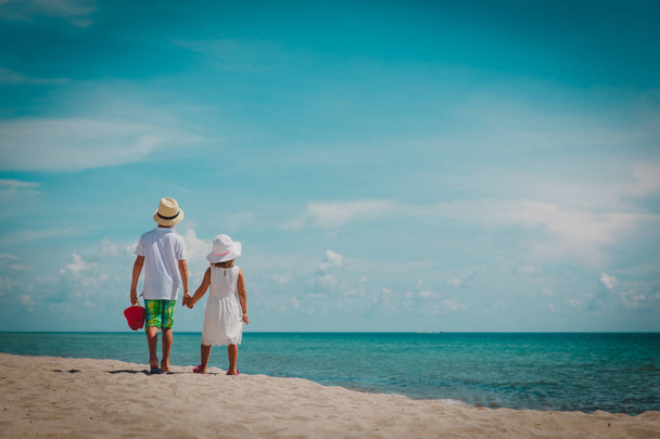 μικρό αγόρι και κορίτσι περπάτημα στην παραλία - Φωτογραφία, εικόνα