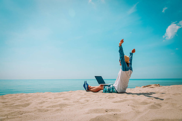 young man working on laptop at beach - Foto, Bild