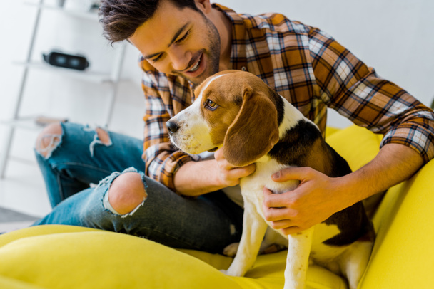 happy handsome man spending time with dog at home - 写真・画像