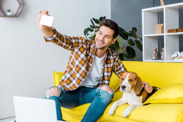 ビーグル犬と selfie を取ってハンサムな笑みを浮かべて男 - 写真・画像