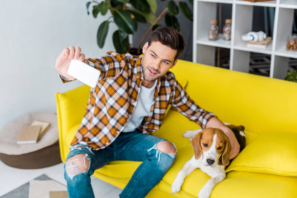 happy man taking selfie on smartphone with cute dog - Foto, Bild