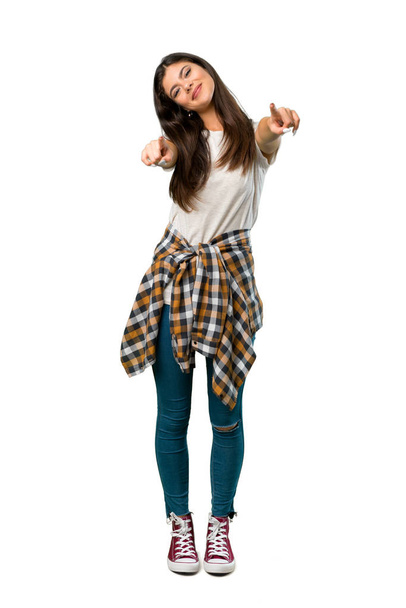 A full-length shot of a Teenager girl with shirt tied to the waist points finger at you while smiling - Foto, imagen