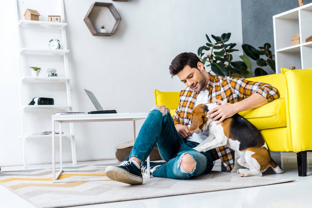 handsome man spending time with dog on floor - Photo, Image
