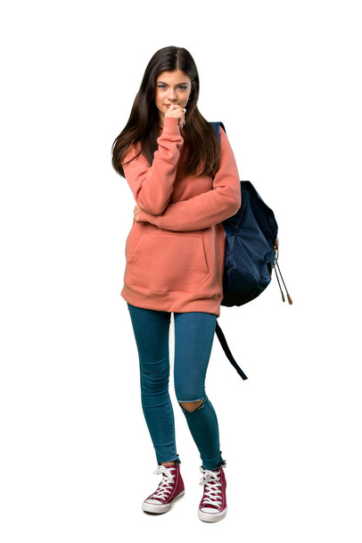 Una foto completa de una adolescente con sudadera y mochila sonriendo y mirando al frente con cara confiada
 - Foto, Imagen