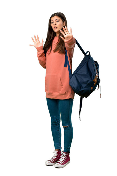 Una toma completa de una adolescente con sudadera y mochila está un poco nerviosa y asustada estirando las manos al frente.
 - Foto, Imagen
