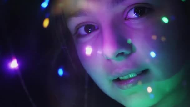 Γκρο πλαν το πρόσωπό του ένα κορίτσι μέσα από φωτεινά φώτα - Πλάνα, βίντεο