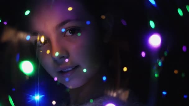 Yakın çekim yüz bir kızın parlak ışıklar ile - Video, Çekim