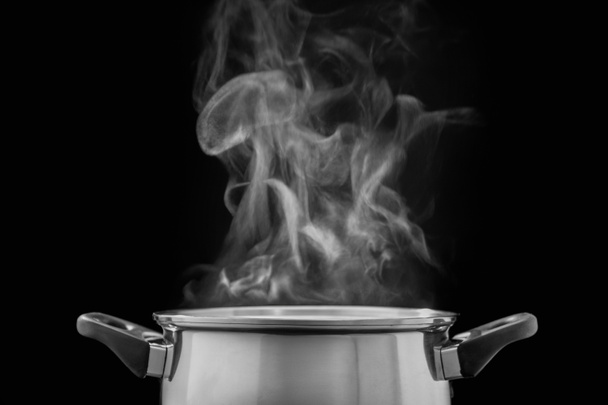 vapor sobre la olla de cocina en la cocina sobre fondo oscuro
 - Foto, Imagen