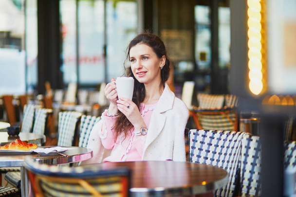 Beautiful young woman drinking coffee in outdoor cafe or restaurant, Paris, France - Φωτογραφία, εικόνα