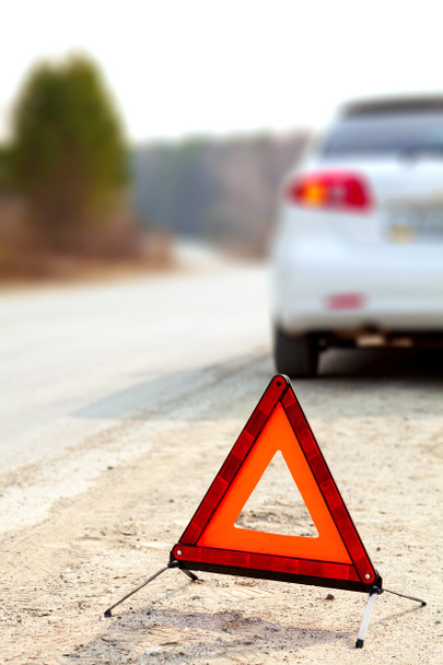 Voiture blanche et un panneau d'avertissement triangle rouge sur la route
 - Photo, image