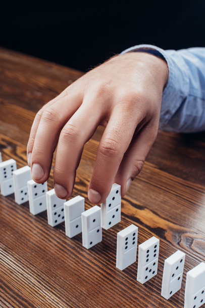 close up view of man picking domino from row on wooden desk - Fotoğraf, Görsel