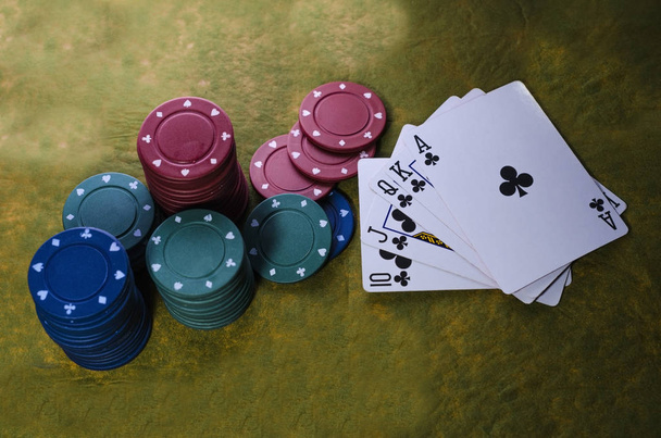 Chips e cartas de jogar em um jogo de poker na escada de fundo verde e preto, completo, pares, trio
 - Foto, Imagem