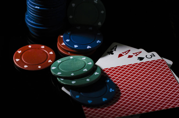 Čipy a hrací karty poker hrát na zelené a černé pozadí žebříku, plný, páry, trio - Fotografie, Obrázek