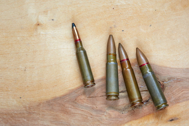 Munitionspatronen des Gewehrs auf der Holzoberfläche. Bild für den Kataloginhalt. - Foto, Bild