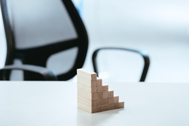 селективный фокус деревянных блоков, символизирующих карьерную лестницу на белом столе
 - Фото, изображение