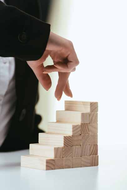 partial view of woman walking with fingers on wooden blocks symbolizing career ladder - Photo, Image