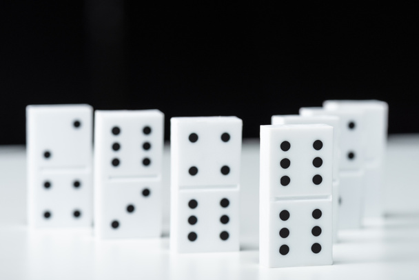 selective focus of domino row isolated on black - 写真・画像