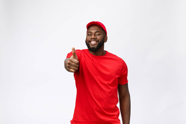 Delivery Concept - Portrait of Happy African American delivery man showing thumbs up. Isolated on Grey studio Background. Copy Space - Fotó, kép